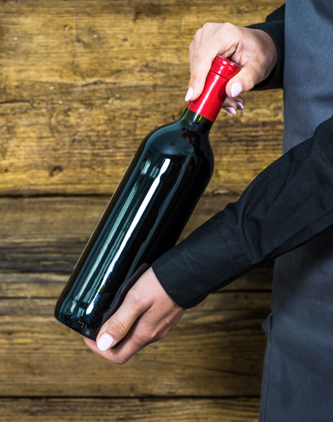 waitress showing red wine bottle to restaurants clients